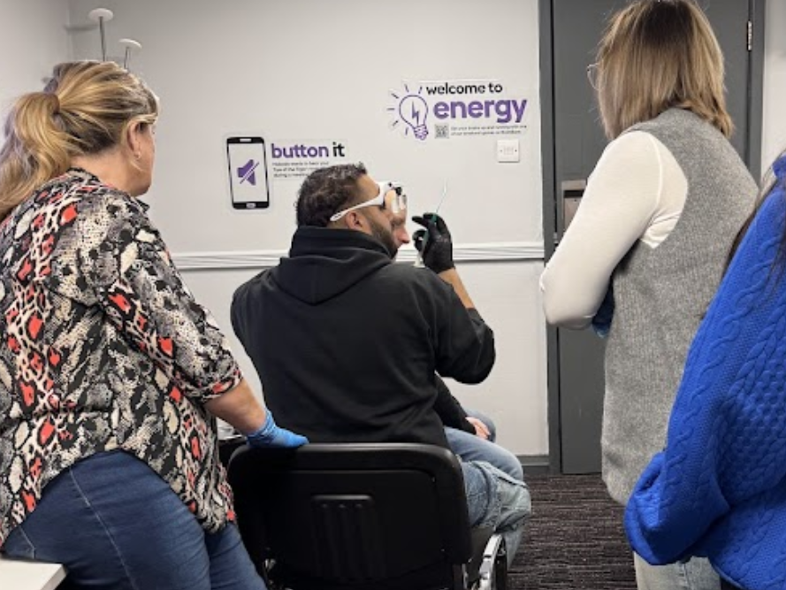 Lead trainer explaining ear wax removal technique to group