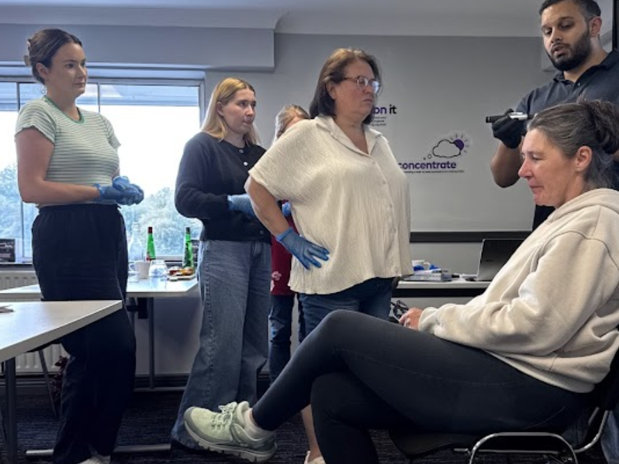 Trainees observing ear examination during practical session