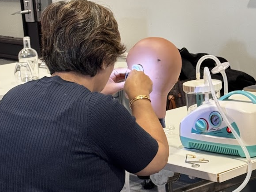 Practitioner performing microsuction wax removal